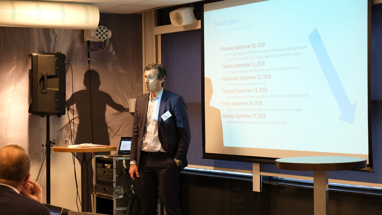 Mann som snakker med power point i bakgrunn. foto