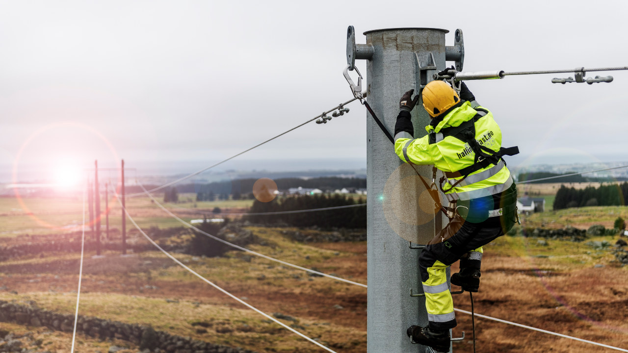 En energimontør jobber oppe i en kraftmast på et jorde. FotoLinje bygging 21 foto FRinge Arbeidet med å bygge ny kraftlinje mellom Kartavoll og Opstad i Hå kommune er i full gang. Dette blir ny hovedlinje for strømforsyning til Sør-Jæren. Det bygges ny transformatorstasjon på Opstad hvor linjen skal knyttes til. Det er Hallingmast som bygger linjen for Lyse Elnett. Fotograf: Fredrik Ringe