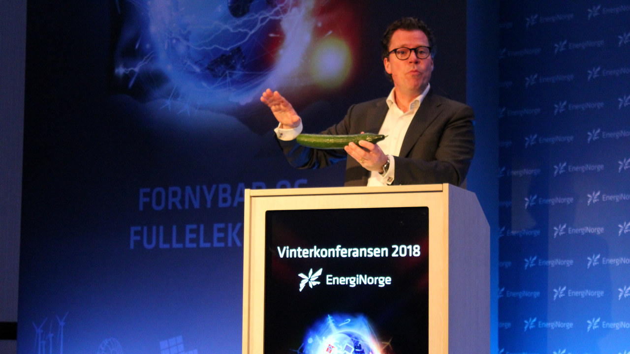 Foto: Morten Helveg Petersen står bak en talerstol og viser fram en agurk.