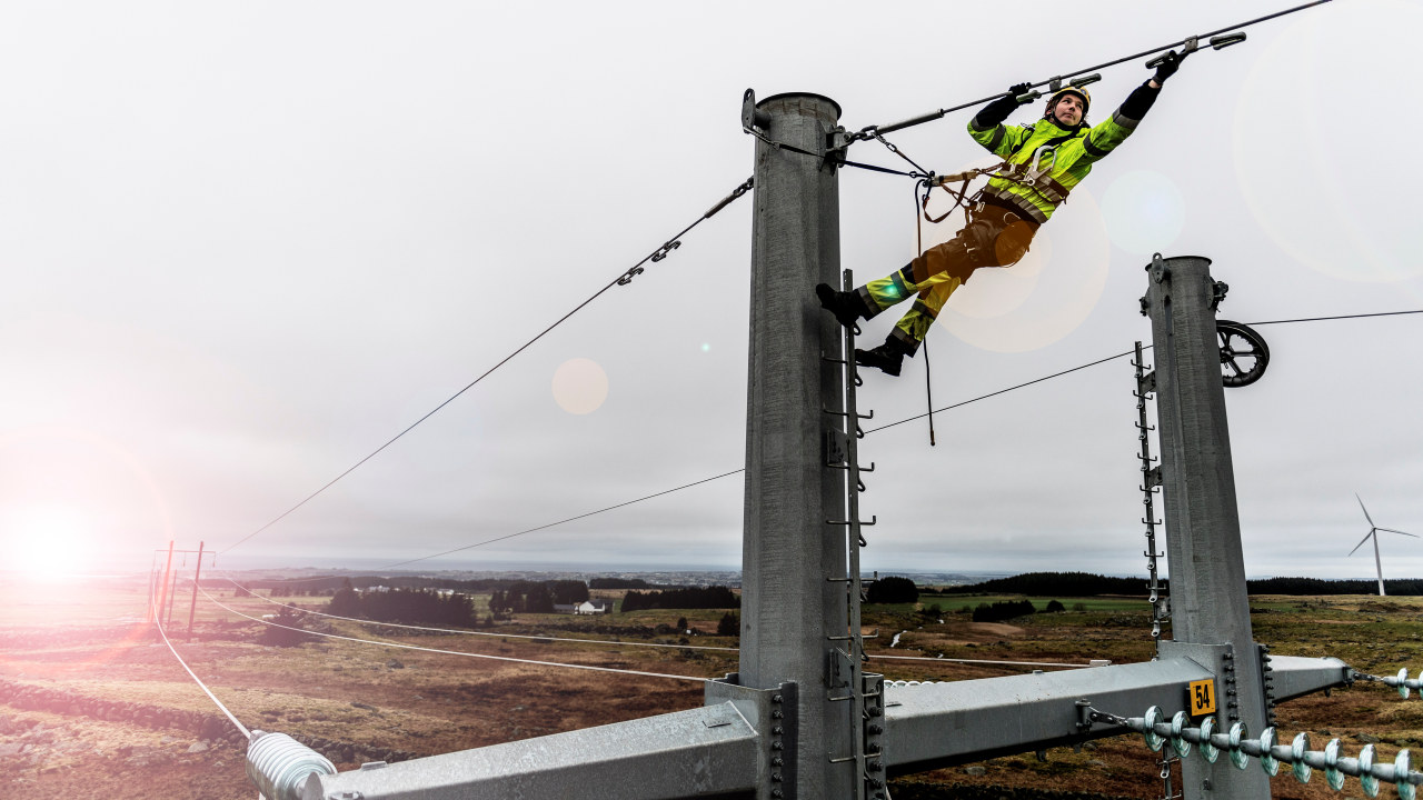 Foto: En energimontør jobber i en strømmast