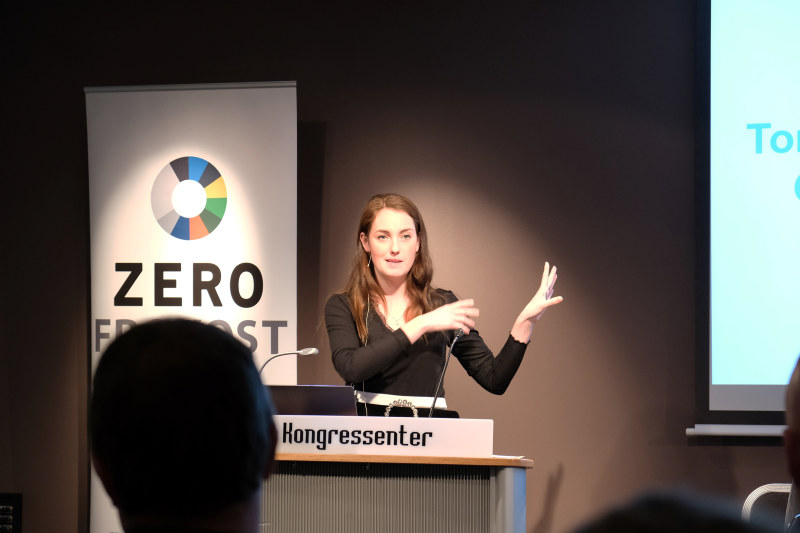 Kvinne bak talerstol med hendene utover. foto