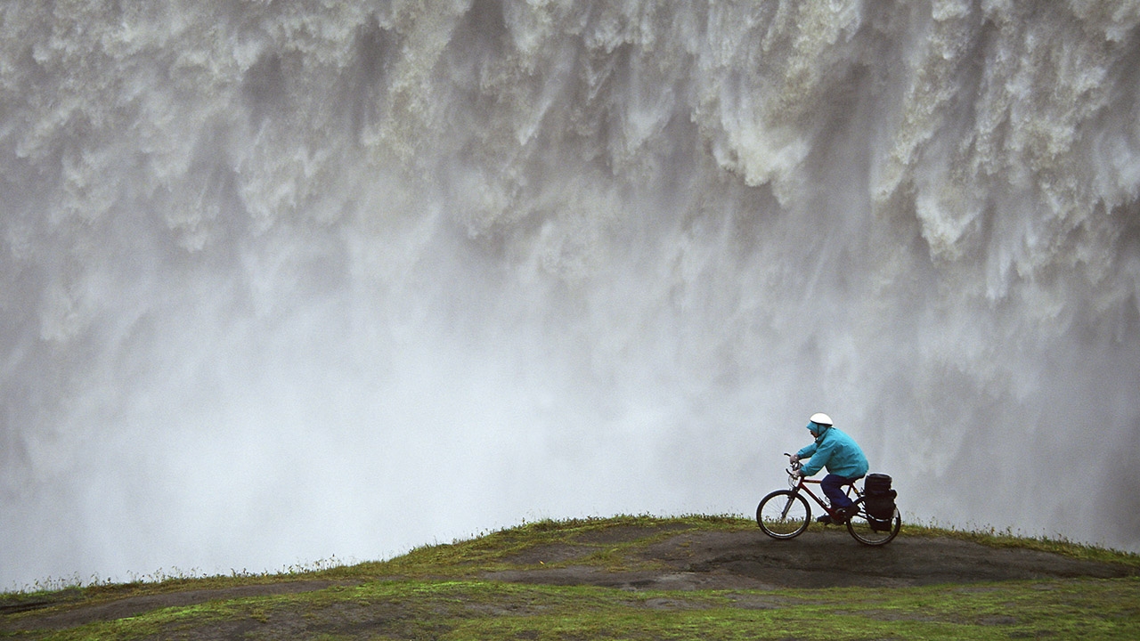 Bilde av foss og person på sykkel