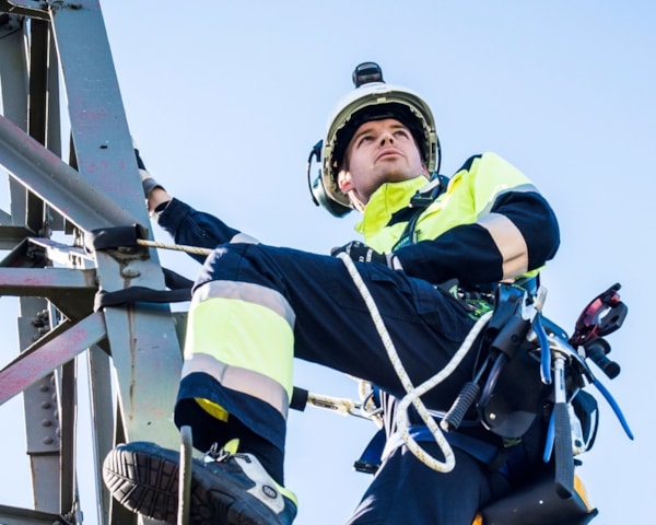 Energimontører klatrer i en kraftmast.