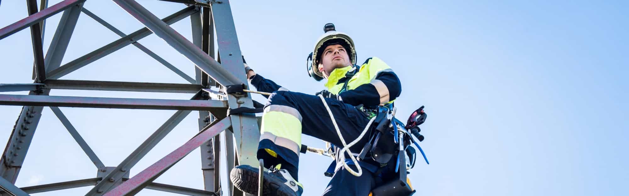 Energimontører klatrer i en kraftmast.