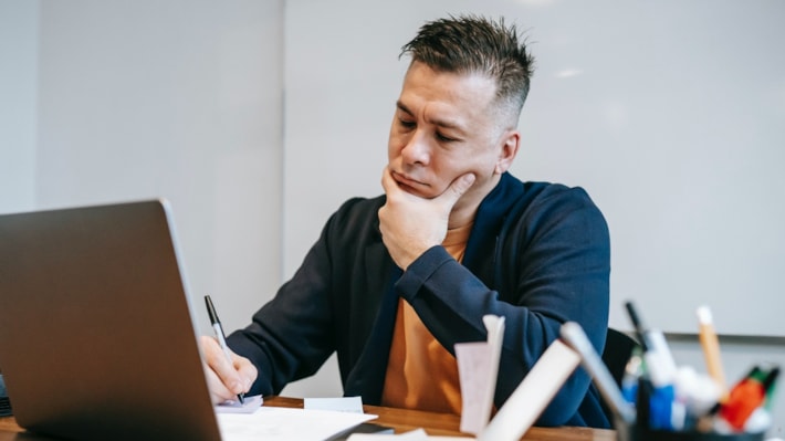 En mann sitter å jobber konsentrert foran en PC.