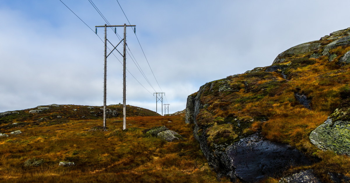 Strømmast i lyngen, med høstlige farger i terrenget.