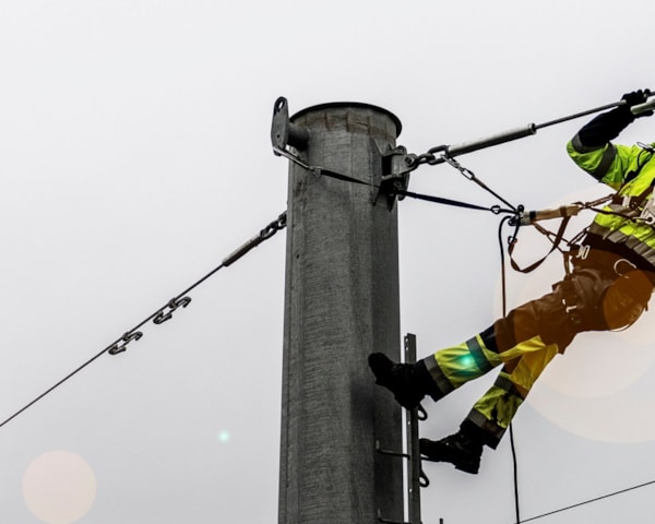 En energimontør jobber i en strømmast